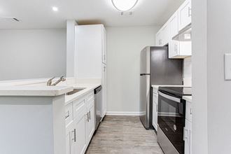 a kitchen with white cabinets and a stainless steel refrigerator