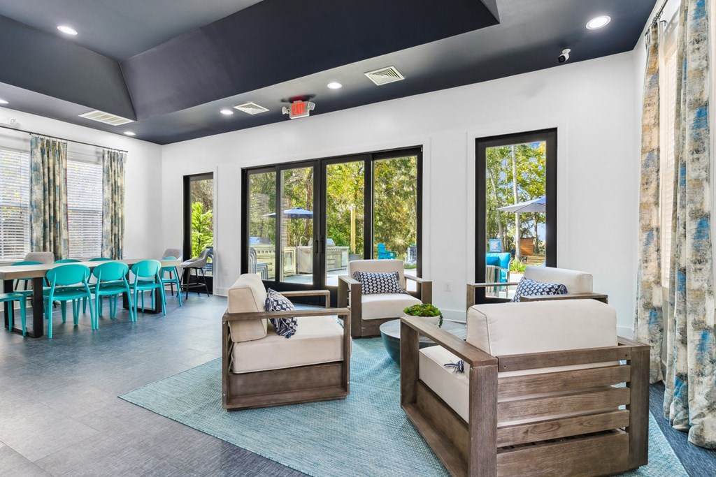 A living room with a blue rug and wooden furniture.