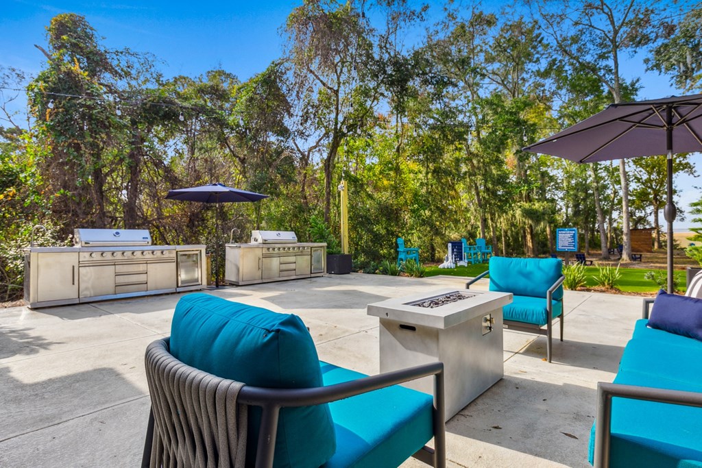 A patio with blue chairs and a table with a white board on it.