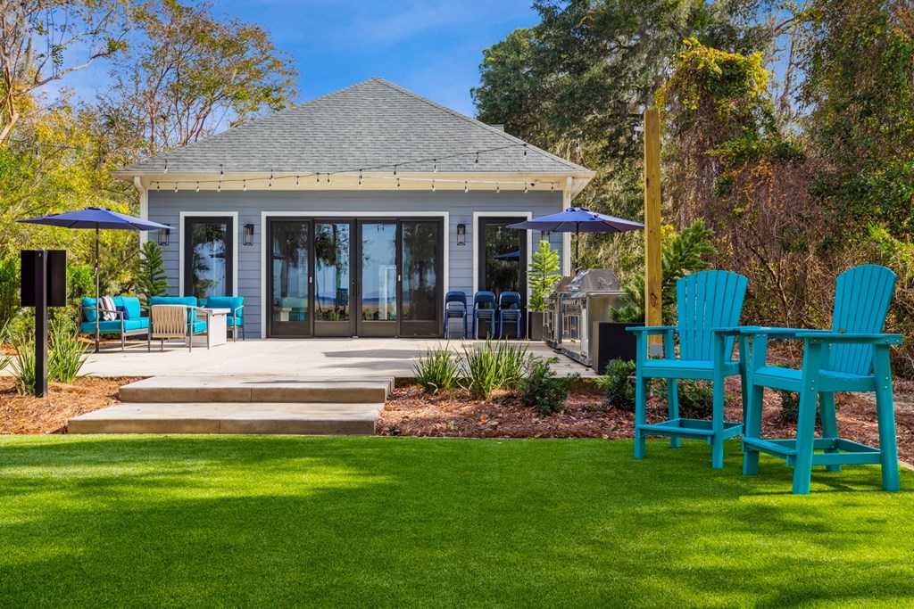 A house with a blue roof and a green lawn.
