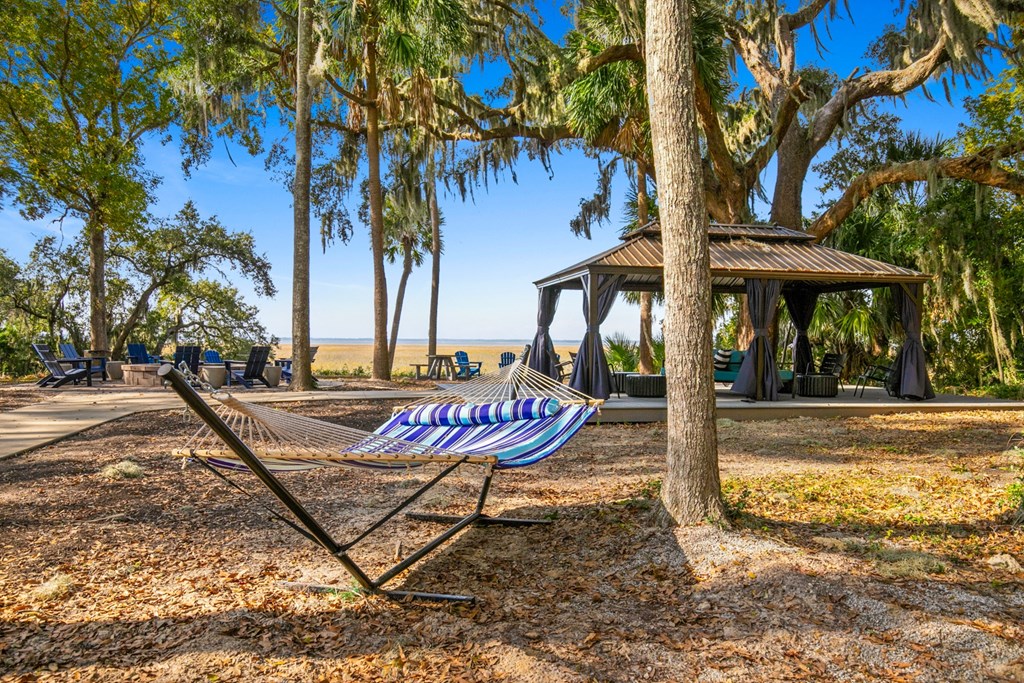 A hammock is strung between two trees in a park.