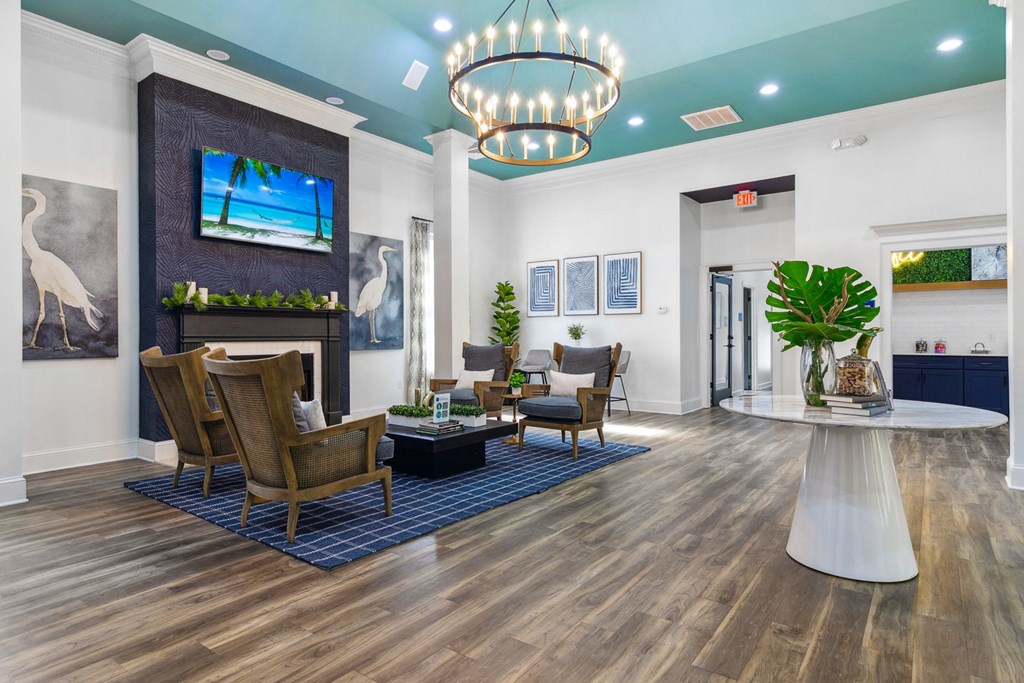 A living room with a wooden floor and a large chandelier.