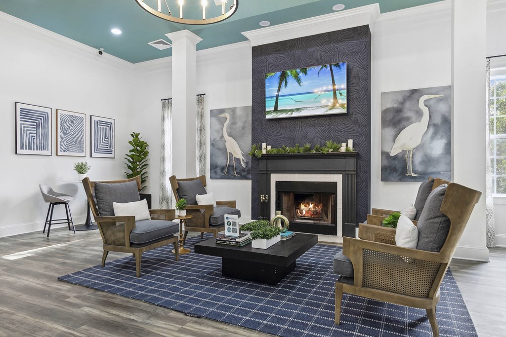 A living room with a fireplace and a painting of a beach scene on the wall.