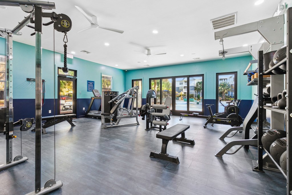 A gym with a variety of equipment including weights and cardio machines.