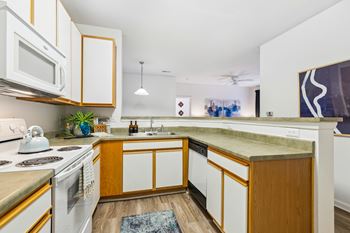 A modern kitchen with white appliances and wooden cabinets.