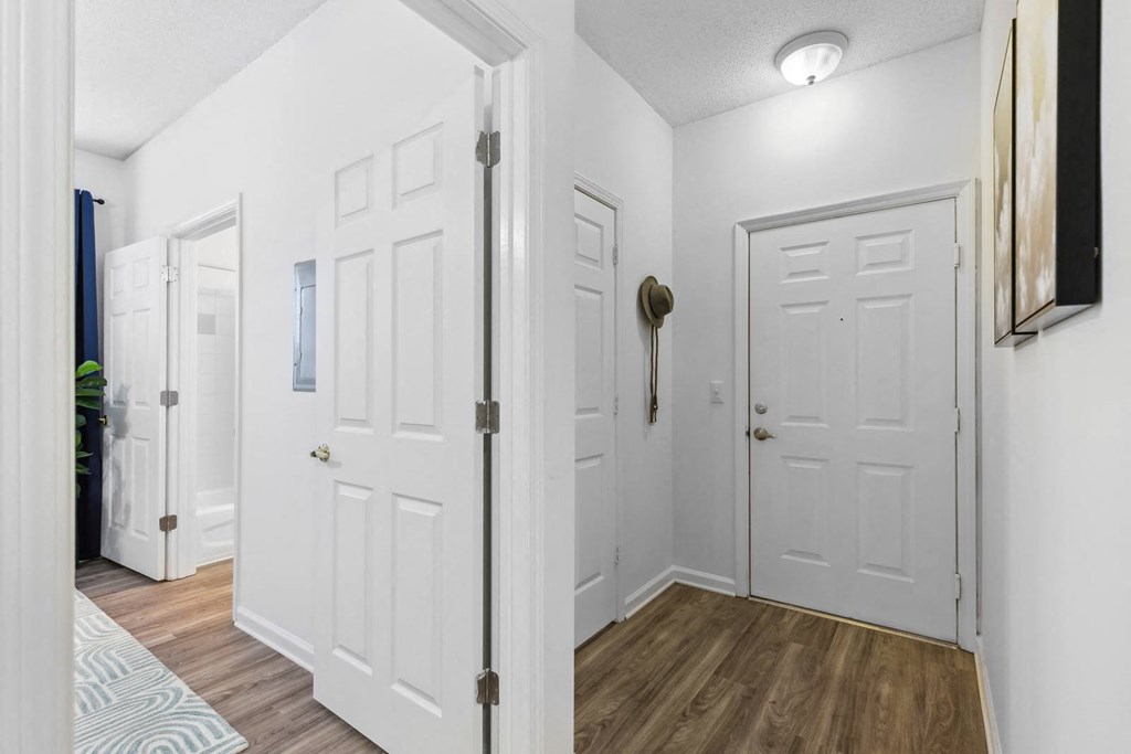 A hallway with white doors and a striped rug on the floor.