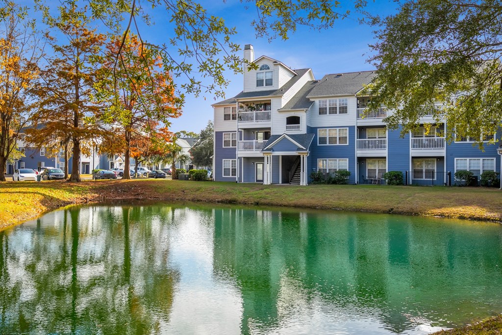 A large building with a pond in front of it.
