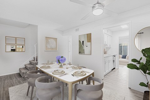 A dining room with a table set for a meal.