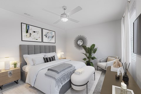 A bedroom with a large bed, a ceiling fan, and a plant.