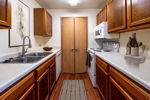 A kitchen with wooden cabinets and a white counter top.