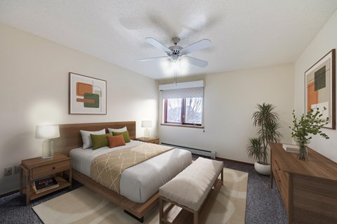 A bedroom with a large bed and a ceiling fan.