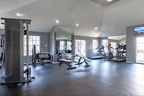 A spacious gym with a variety of equipment including treadmills, weights, and exercise machines.