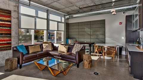 A living room with a brown couch and a glass coffee table.