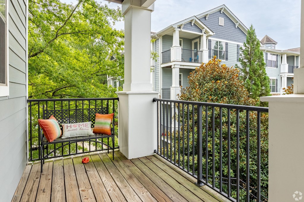 a bench on a porch with a house in the background