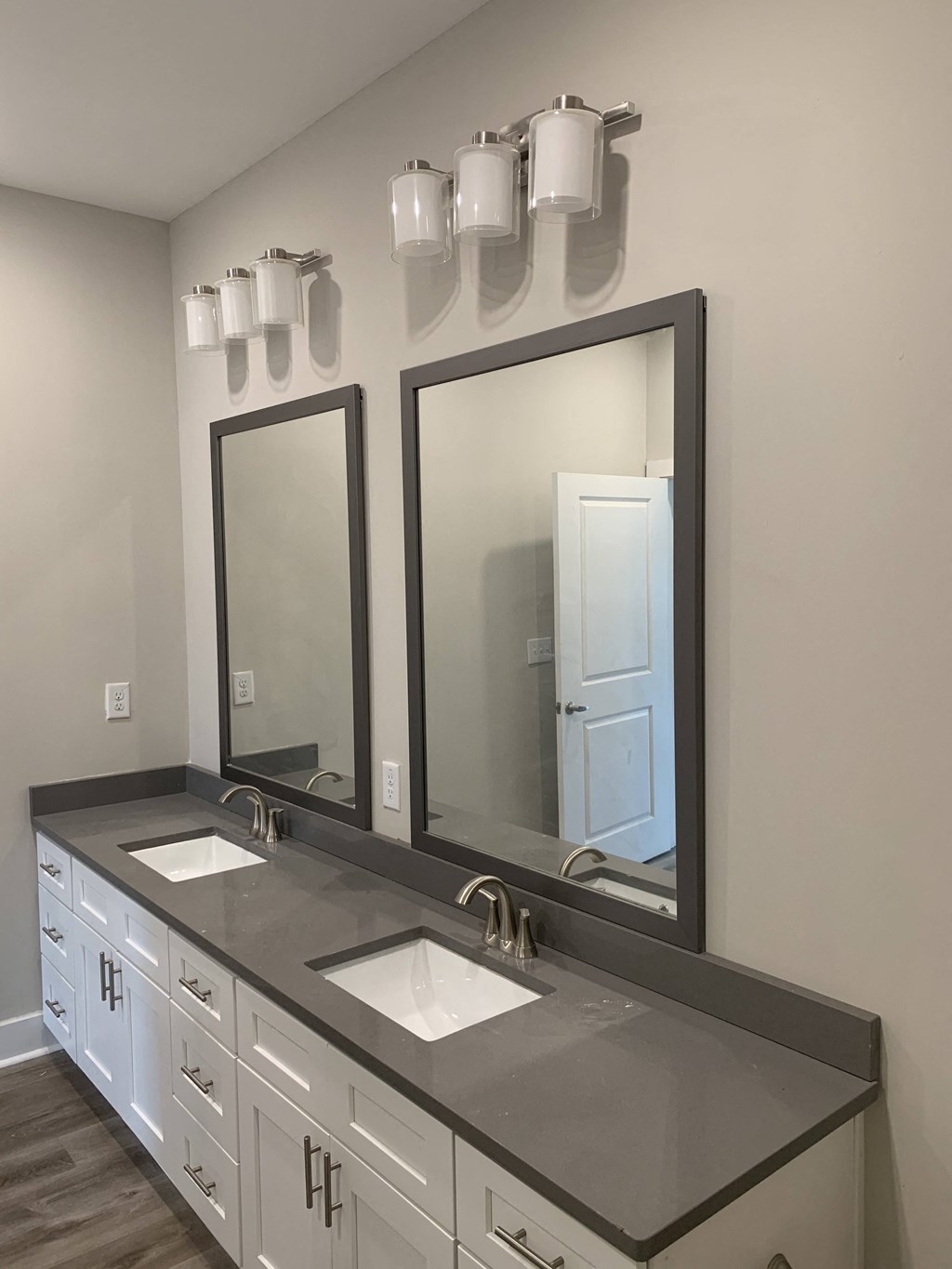 a bathroom with two sinks and two mirrors
