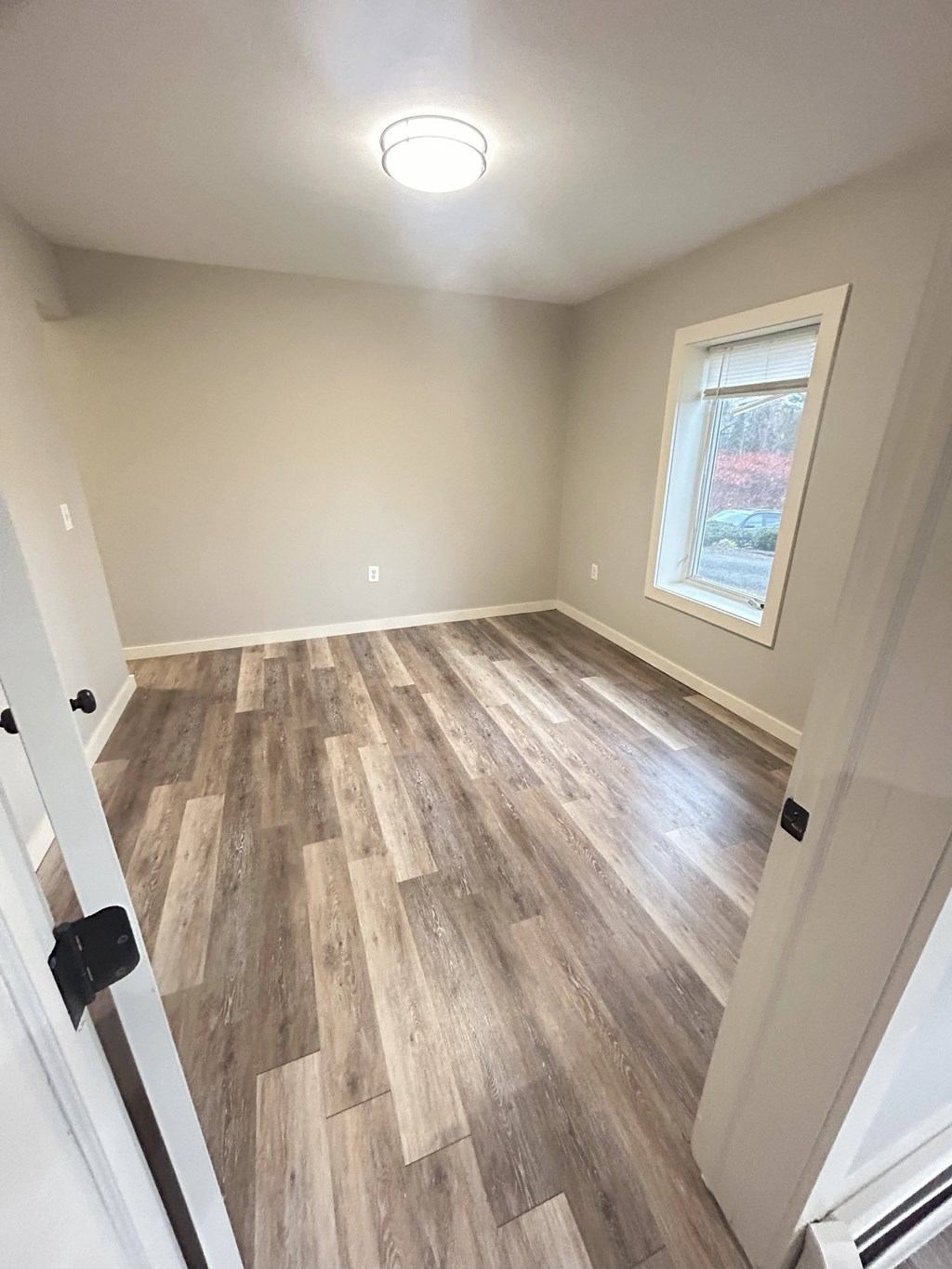 an empty room with wood floors and a window at Briarcliff at Quechee Apartments, Quechee, VT