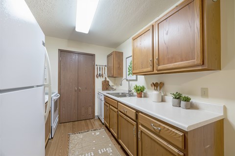 A kitchen with wooden cabinets and a white fridge.