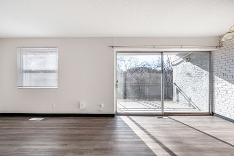 A room with a sliding glass door leading to a balcony.