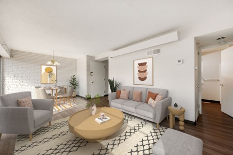 A living room with a grey couch, a coffee table, and a painting on the wall.