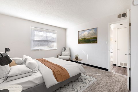 A bedroom with a large bed and a painting on the wall.
