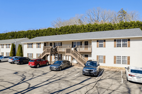 a parking lot with cars in front of an apartment building