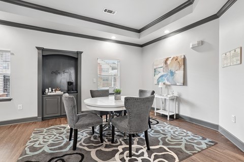 A dining room with a white table and grey chairs.