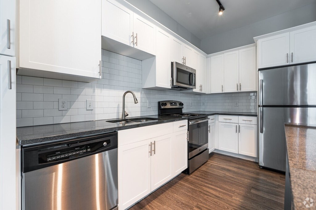 A kitchen with white cabinets and a black stove top.at Century Baxter Avenue, Louisville Kentucky