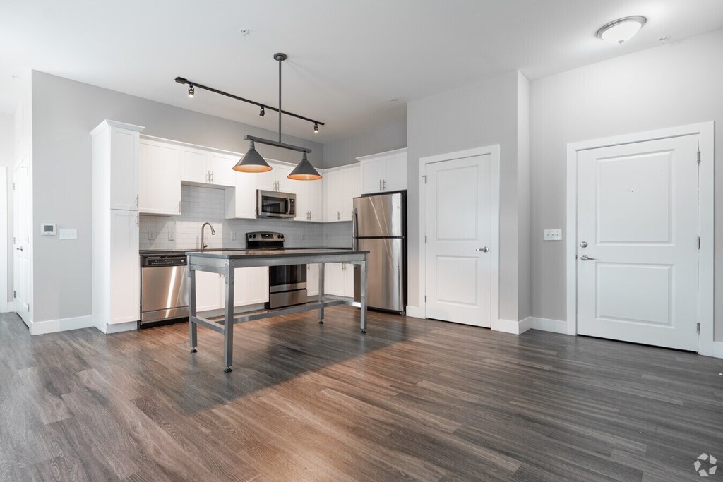 A modern kitchen with a wooden floor and white walls.at Century Baxter Avenue, Louisville Kentucky