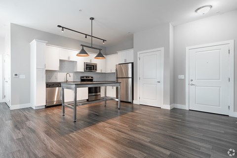 A modern kitchen with a wooden floor and white walls.at Century Baxter Avenue, Louisville Kentucky