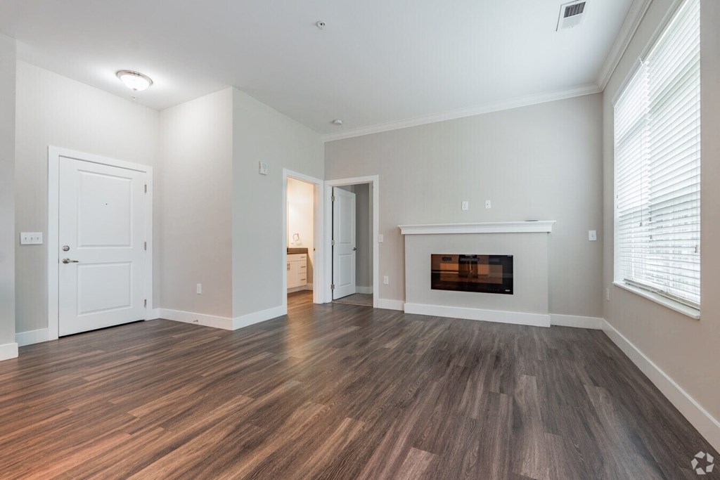 A room with a fireplace and wood flooring.at Century Baxter Avenue, Louisville Kentucky