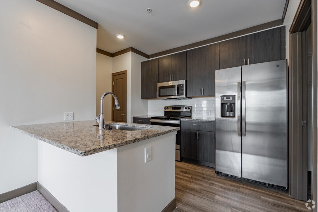 A kitchen with a granite countertop and stainless steel appliances. at Century Belmont Station, Louisville, Kentucky