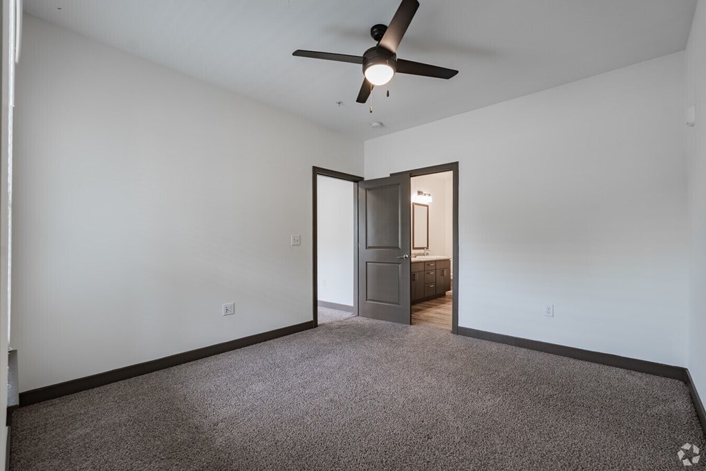 A room with a ceiling fan and a carpeted floor. at Century Belmont Station, Louisville, 40243