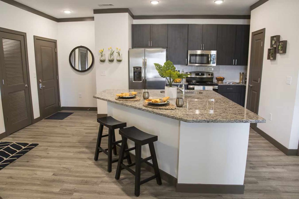 A kitchen with a bar stool in front of the island. at Century Belmont Station, Louisville, KY