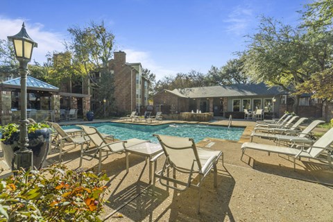 A pool area with chairs and a lamp post.