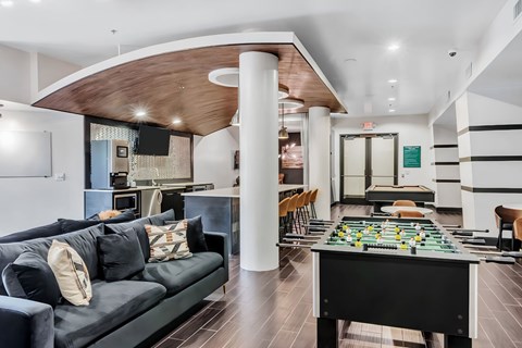 A game room with a foosball table and a couch.