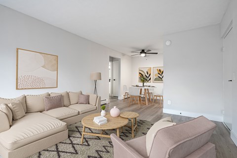 A living room with a beige couch, a coffee table, and a painting on the wall.