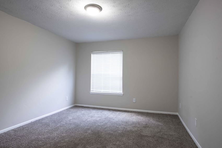 an empty room with white walls and a window