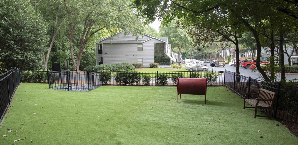 the back yard of a house with a lawn and a red chair
