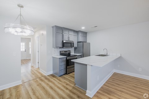 A kitchen with a white countertop and a microwave above it.