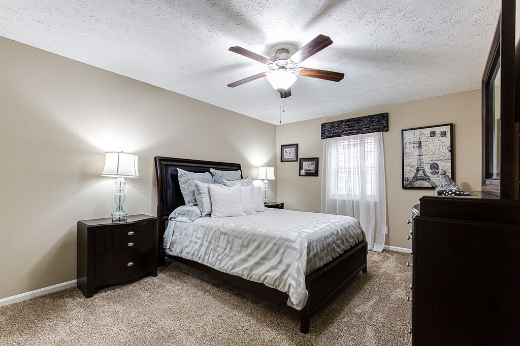 a bedroom with a large bed and a ceiling fan