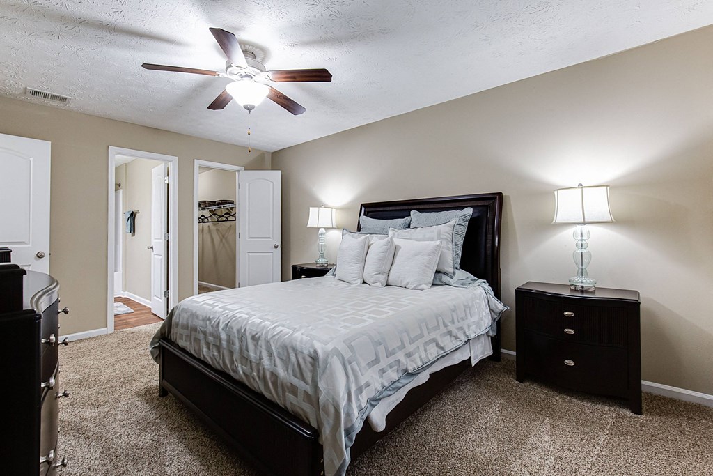 a bedroom with a large bed and a ceiling fan