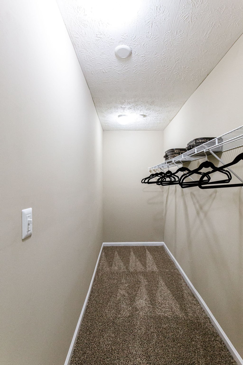 an empty room with a shoe rack on the wall