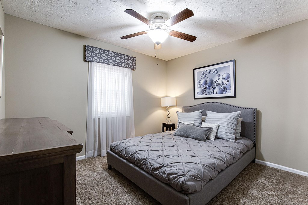 a bedroom with a bed and a ceiling fan