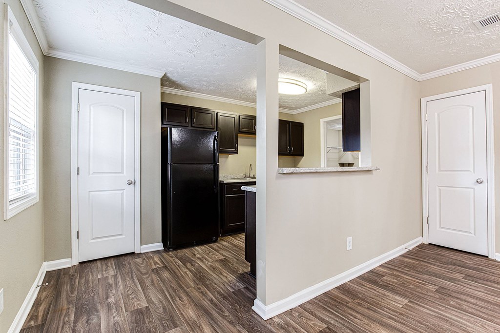 an empty kitchen with a black refrigerator and a black