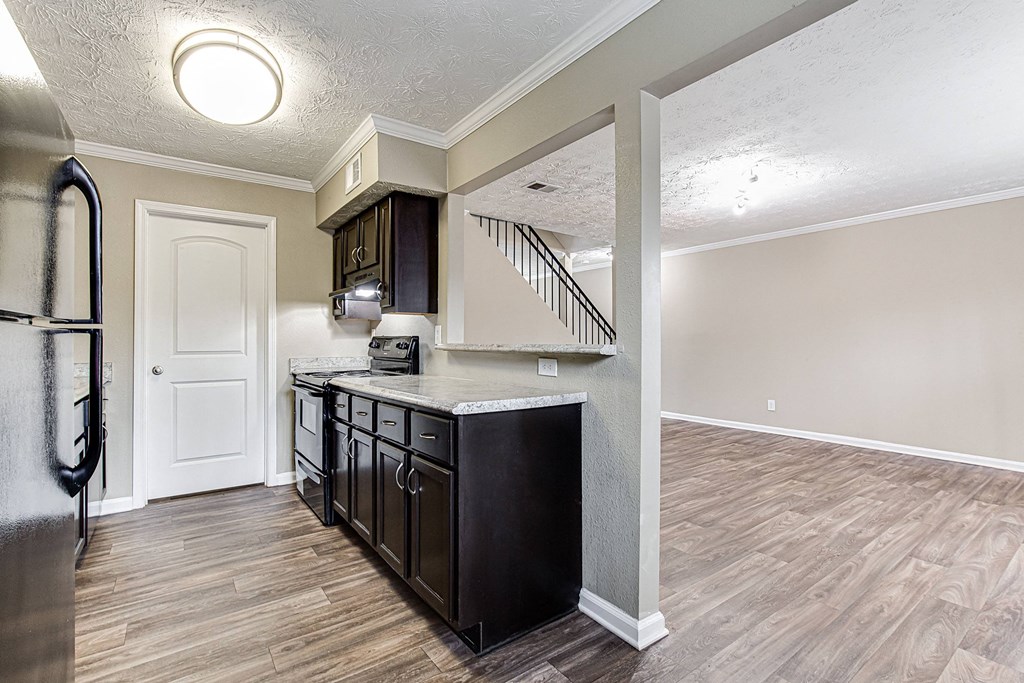 an open kitchen and living room with a stainless steel refrigerator
