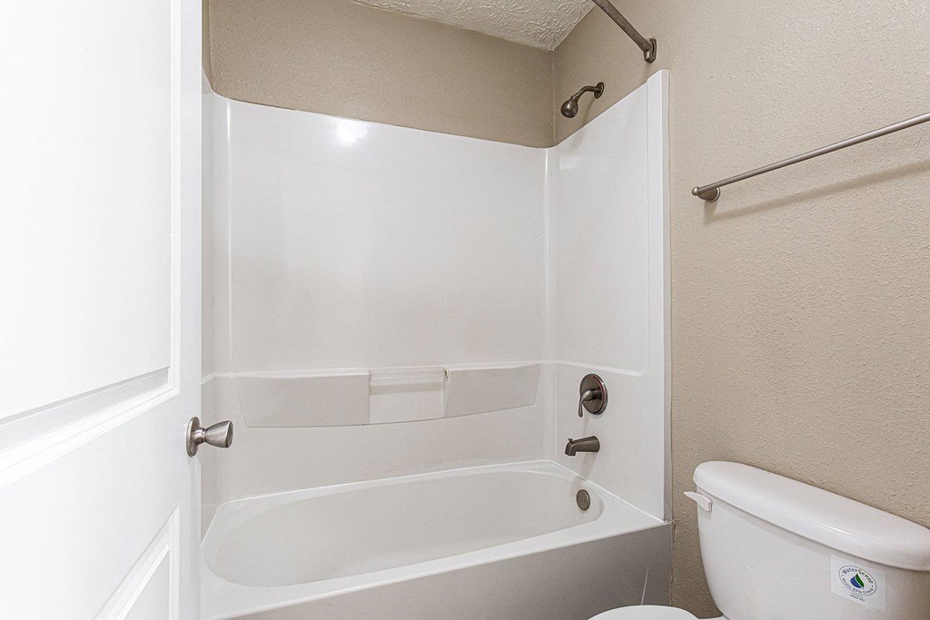 a bathroom with a tub and a toilet and a window