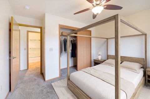 A bedroom with a large bed and a ceiling fan.