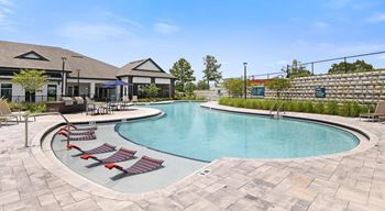 A large outdoor swimming pool surrounded by red lounge chairs.at Century Grove Park, North Carolina