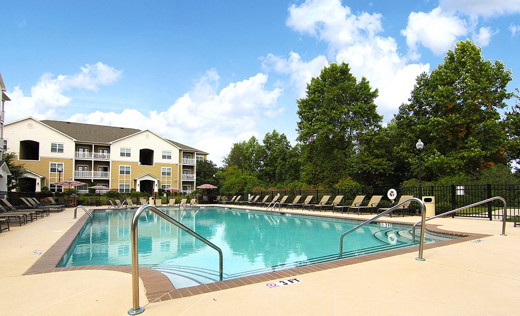 Sparkling pool with sundeck and lounge chairs at the Haven at Reed Creek Apartments Martinez, GA