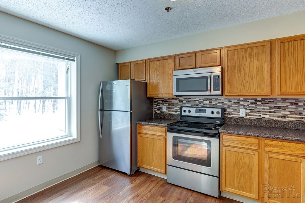 a kitchen with stainless steel appliances and wooden cabinets